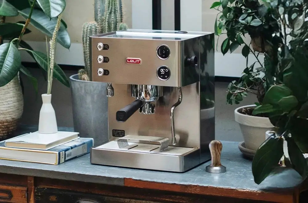 Lelit Anna espresso machine placed on a desk with plants, highlighting its compact design suitable for home or office.
