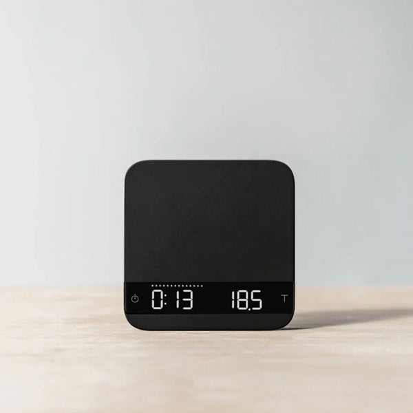 Black Acaia Lunar espresso scale showing digital timer and weight readout in a modern minimalist style.