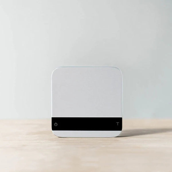 Front view of the Acaia Lunar espresso scale in grey with sleek black touch panel.