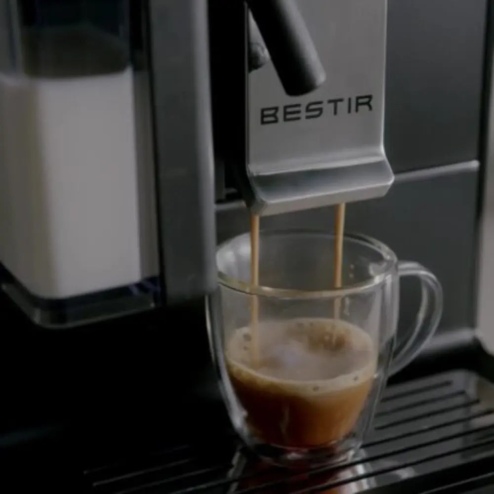 Close-up of Bestir Melange brewing espresso into clear glass cup.