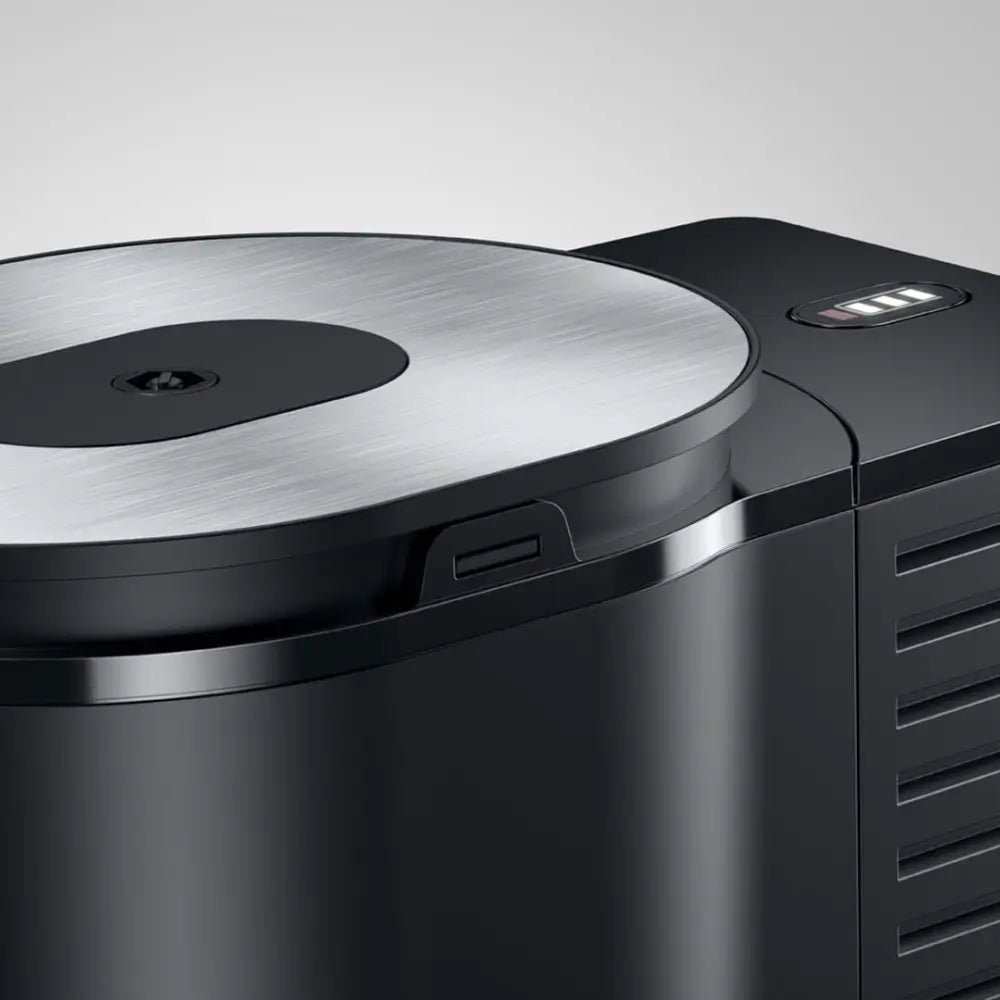 Close-up detail of the brushed stainless steel lid and the black casing of the Jura Cool Control milk container.