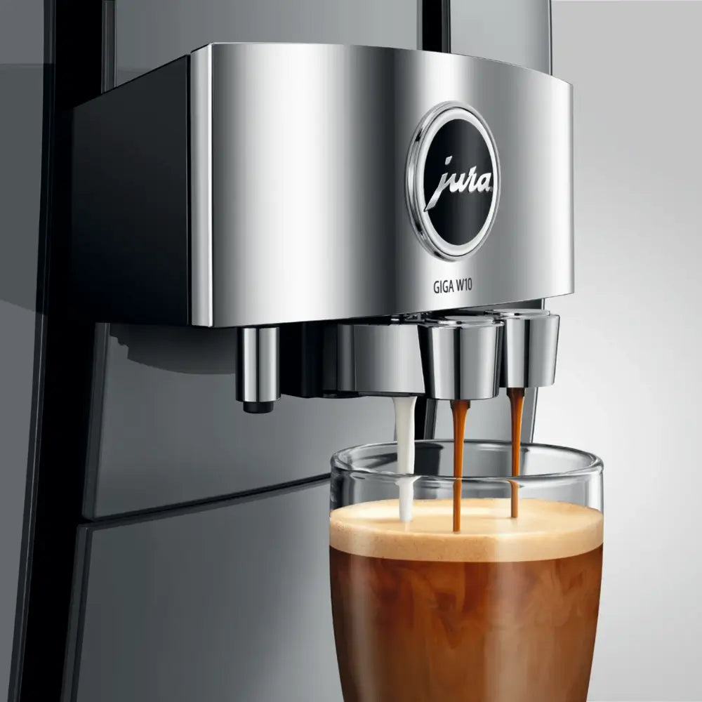 Close-up of Jura Giga W10 automatic coffee machine spout pouring milk and espresso