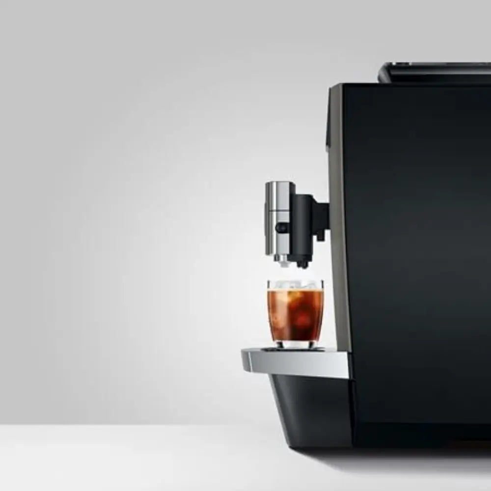 Side view of Jura X10c coffee machine brewing iced coffee into a glass.