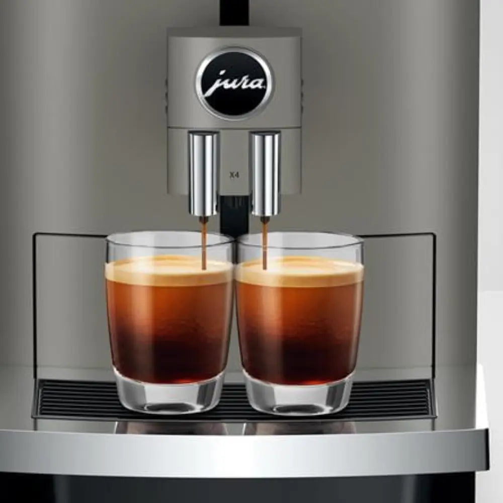 Close-up of the Jura X4 dispensing two espresso cups simultaneously.