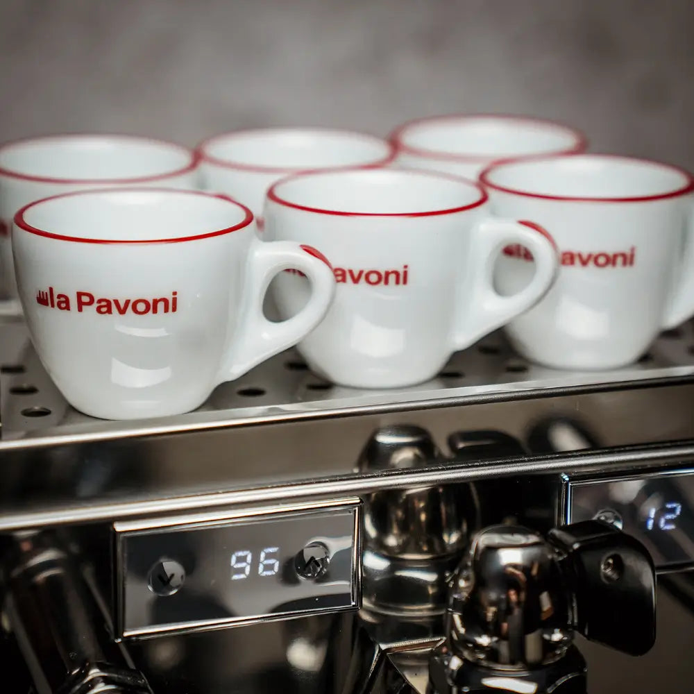 Close-up of La Pavoni espresso cups warming on the tray, with the PID digital temperature display visible below.