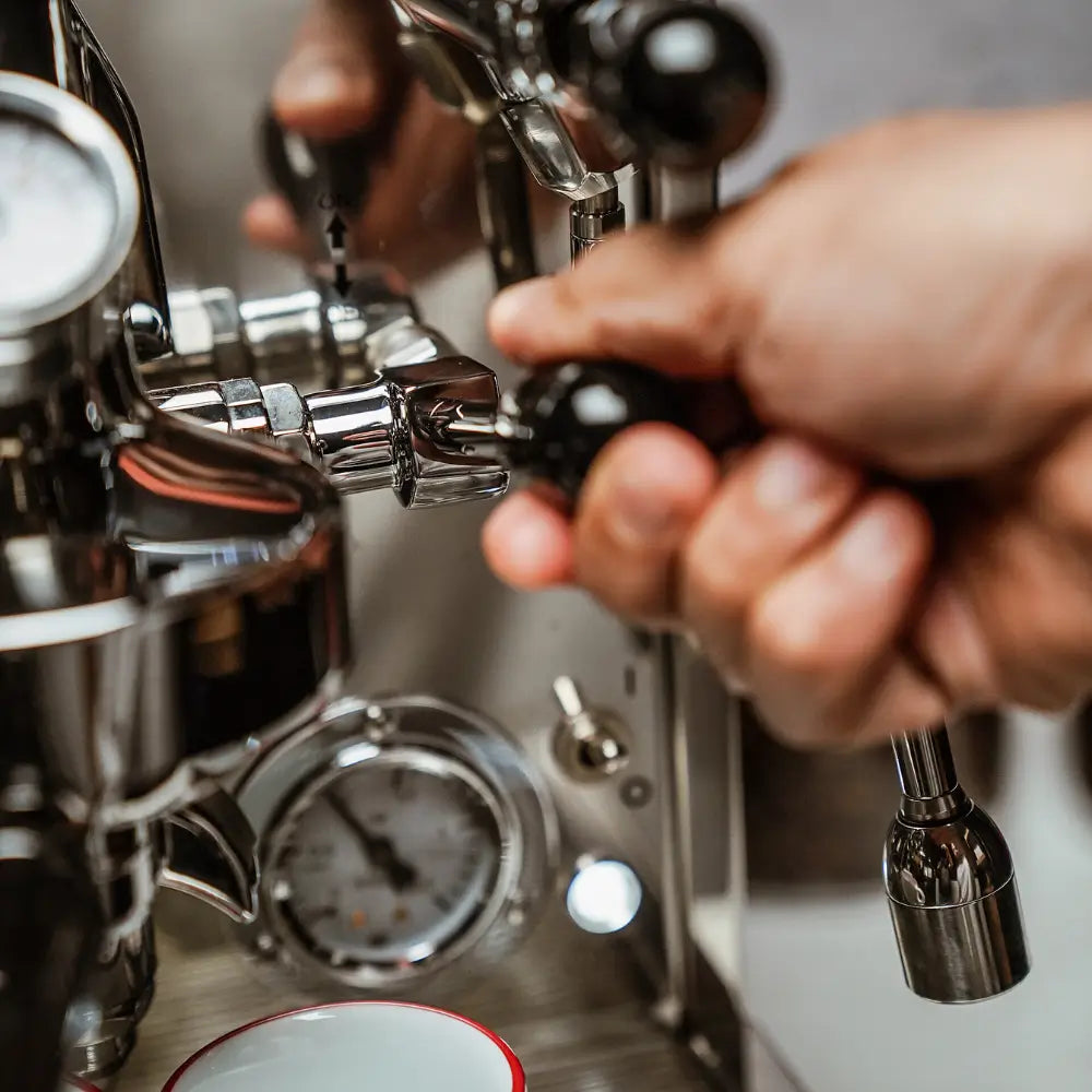 A hand operating the rotary steam or hot water valve on the La Pavoni Botticelli semi-professional machine.
