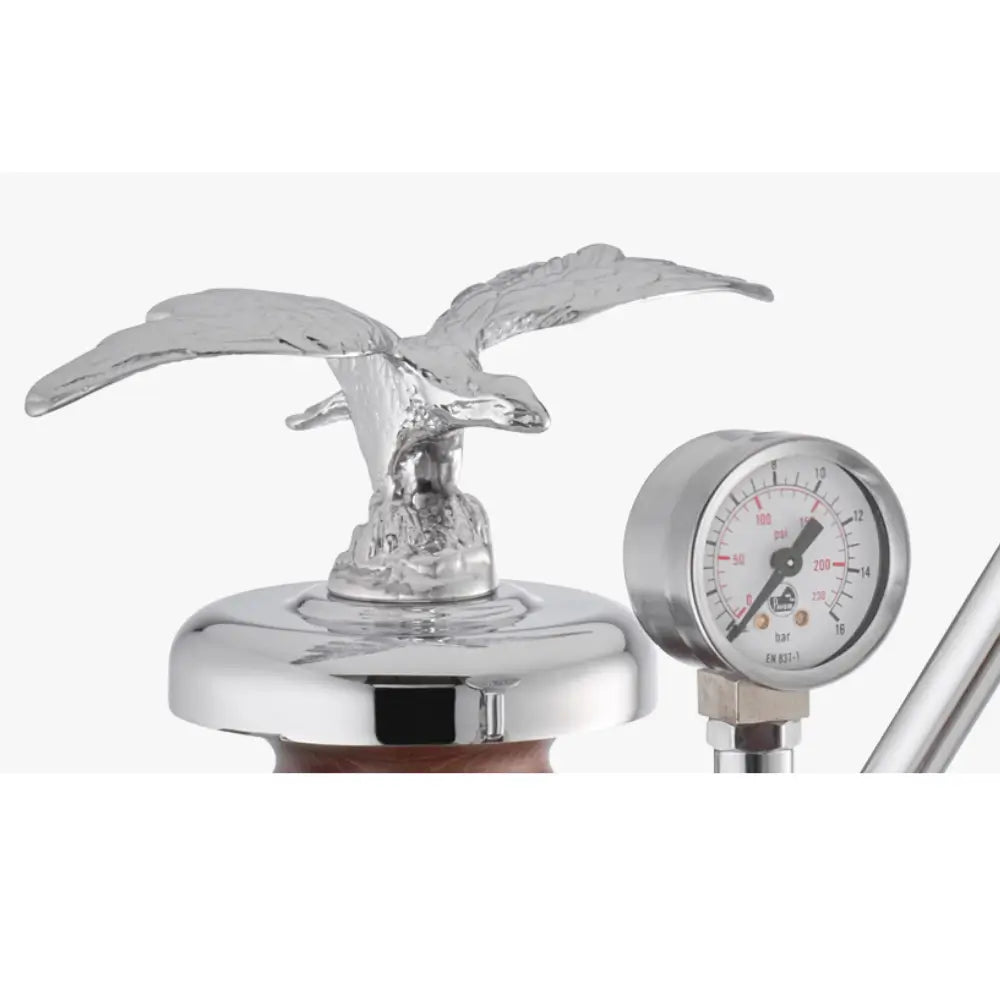 A close-up of the chrome eagle ornament and the boiler pressure gauge on the La Pavoni Esperto Abile.