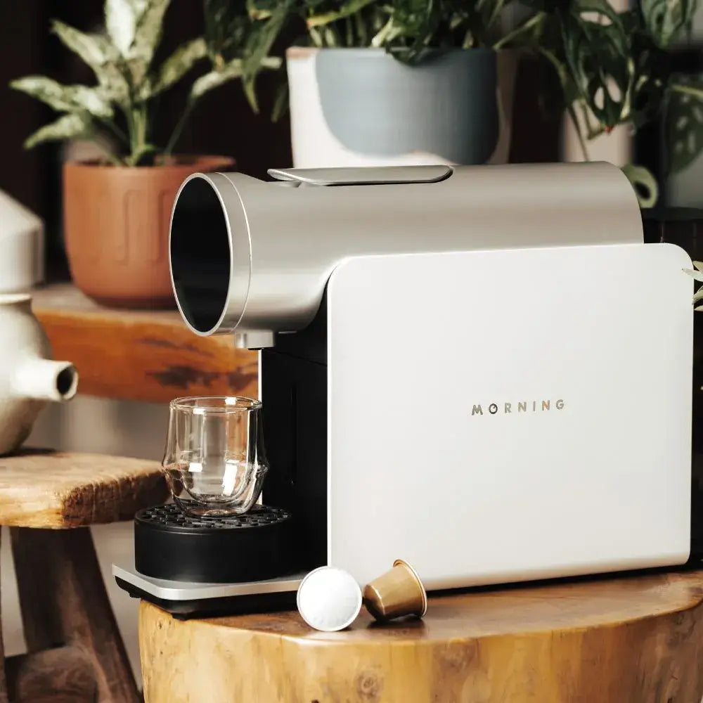Morning Coffee Machine 220v in white brewing espresso into a glass cup with another machine in background.