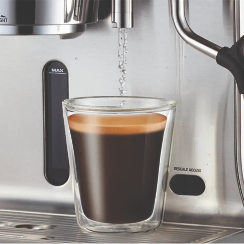 The Sage Dual Boiler dispensing hot water into a clear glass cup, ideal for Americanos or pre-heating espresso cups.