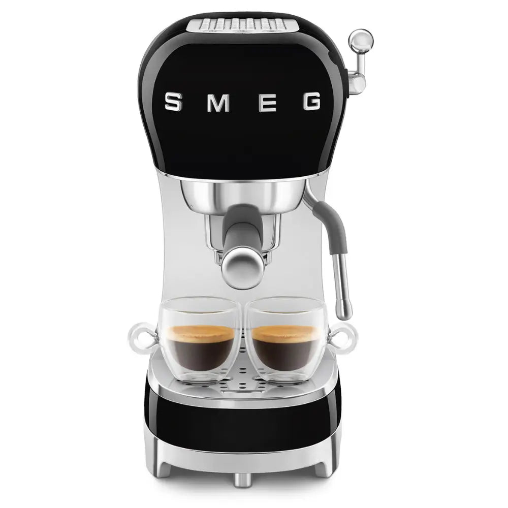 Front view of the SMEG ECF02 actively brewing two shots of espresso into small glass mugs.