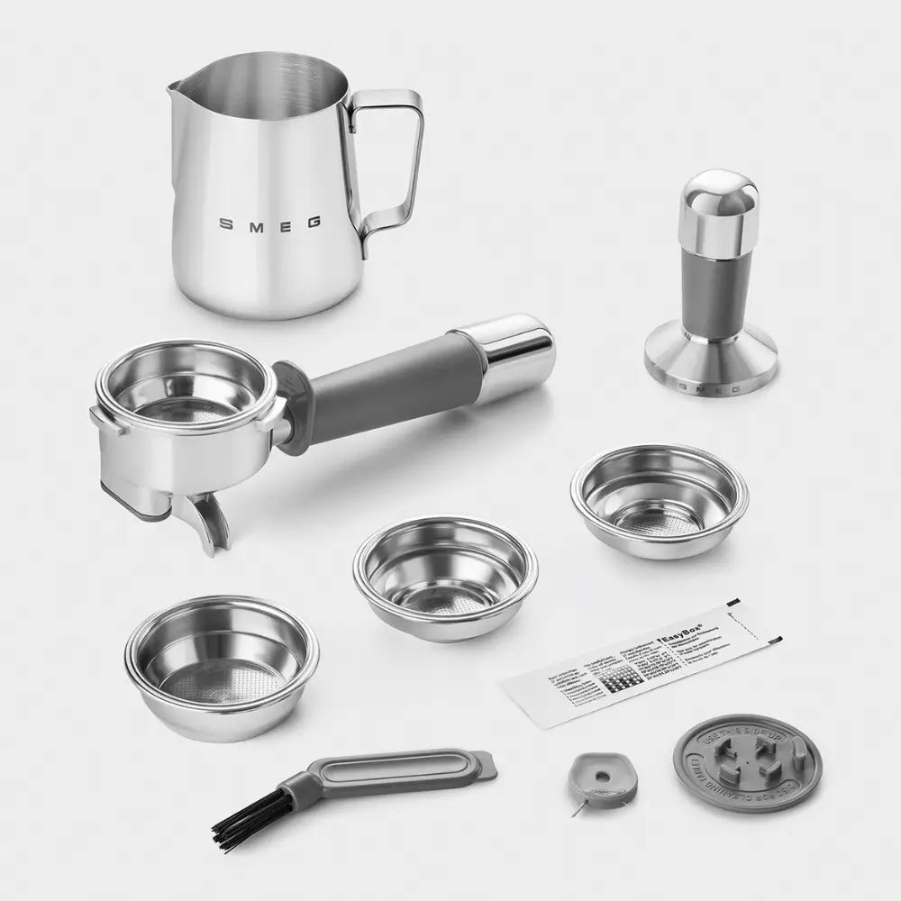 Photo of all included accessories: milk frothing pitcher, portafilter, tamper, filter baskets, and cleaning brush.