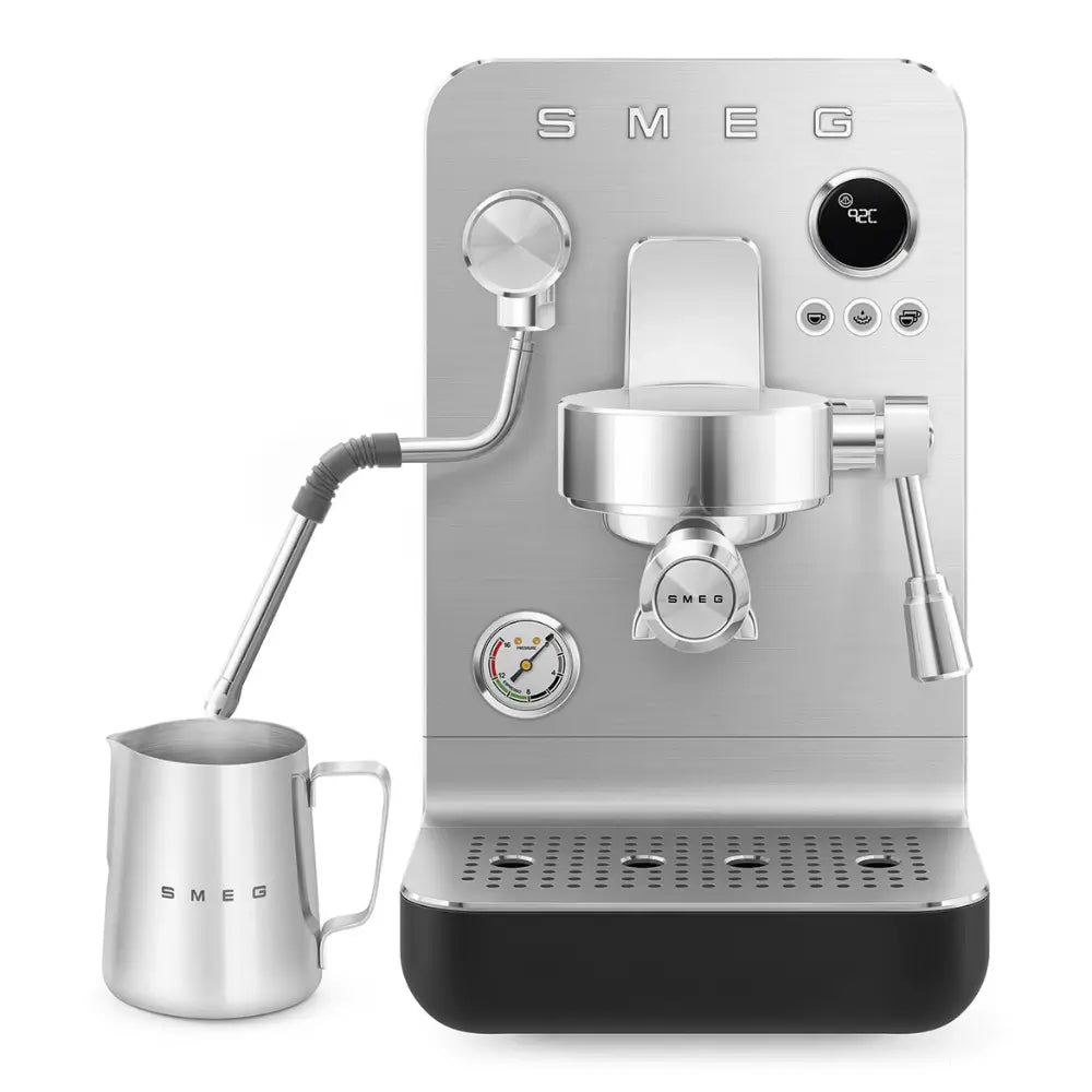 Front view of the SMEG Collezione Minipro with the steam wand submerged in a milk frothing jug.