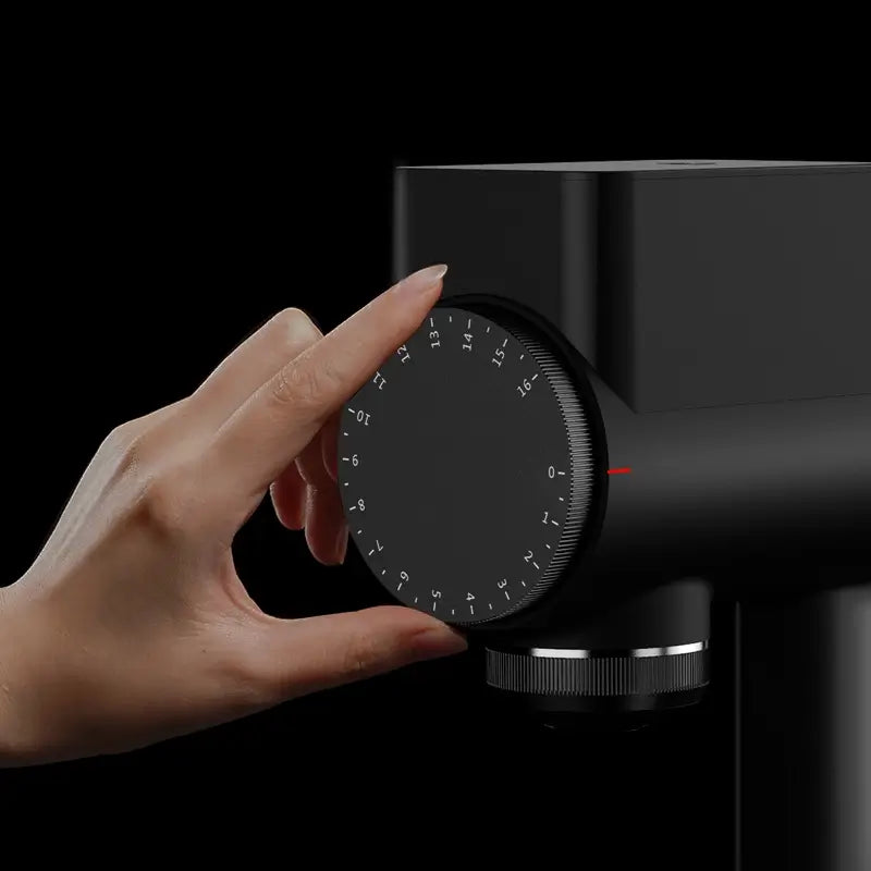 Hand adjusting grind size dial on Timemore Sculptor 064S grinder.