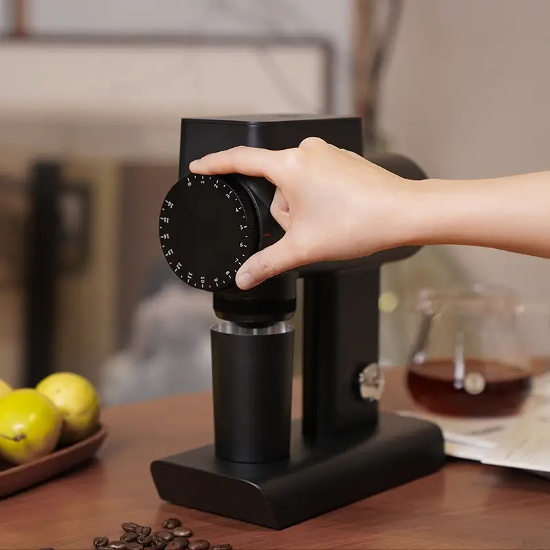 User rotating grind size dial on black Timemore Sculptor 064S coffee grinder.