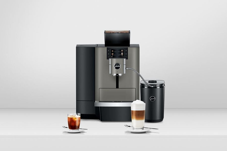 JURA X10 Automatic Coffee Machine with 2 coffees and spoons on a studio table.