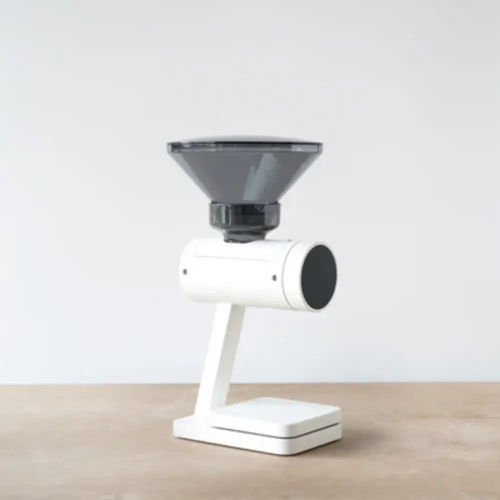 Side view of the Acaia Orion Nano coffee bean doser in white with a transparent hopper on a wooden surface.
