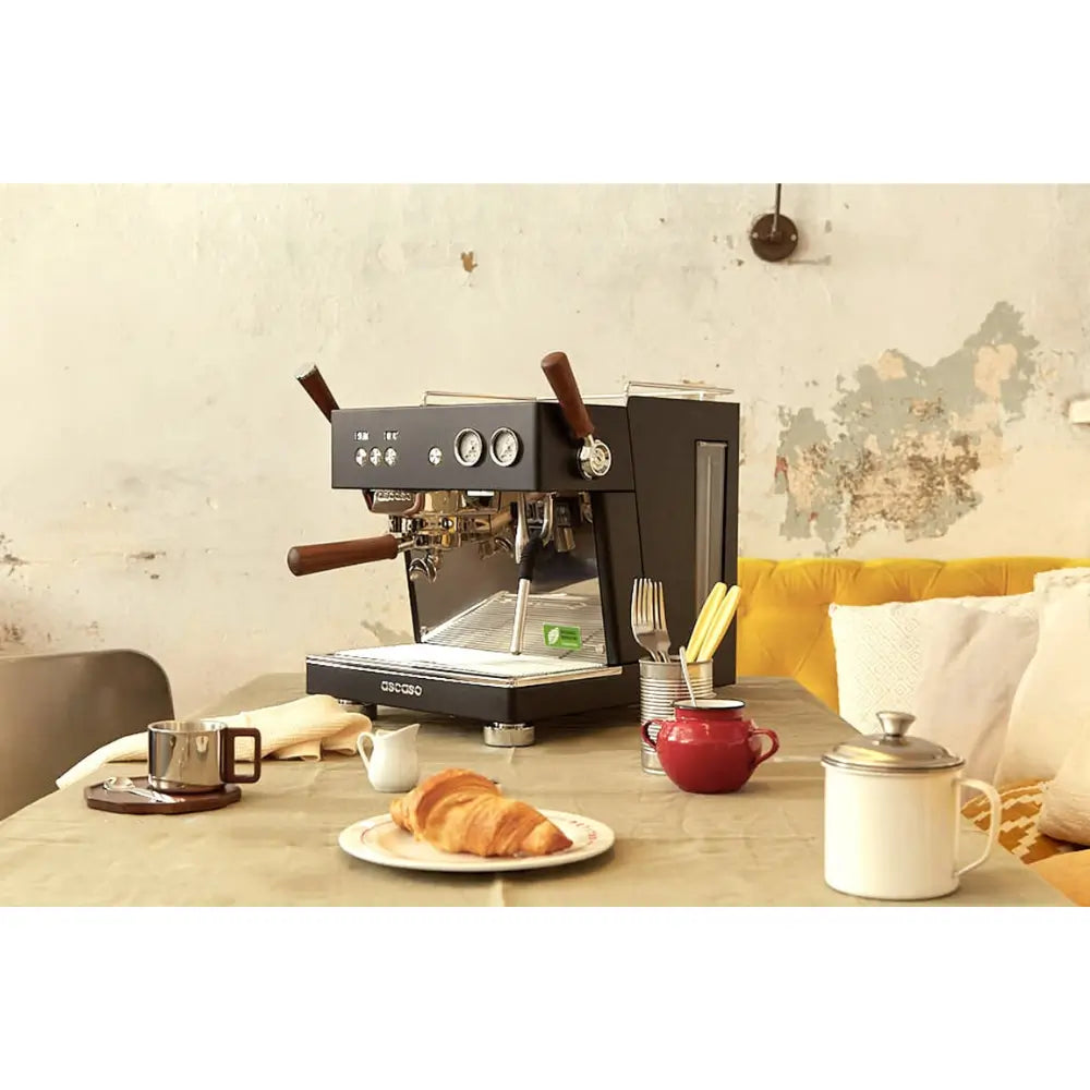 Ascaso Baby T Plus espresso machine on a rustic café table.