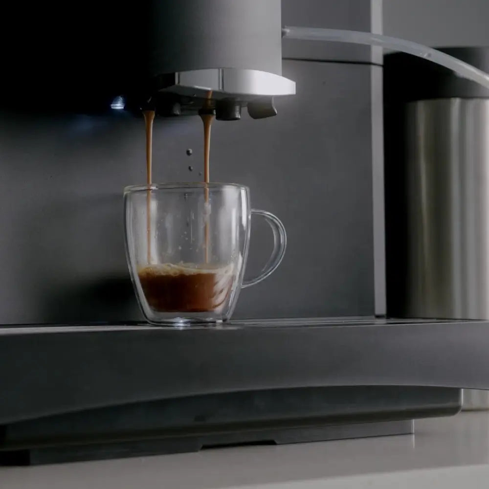 Close-up of Bestir BM40 brewing fresh espresso into a clear glass cup.