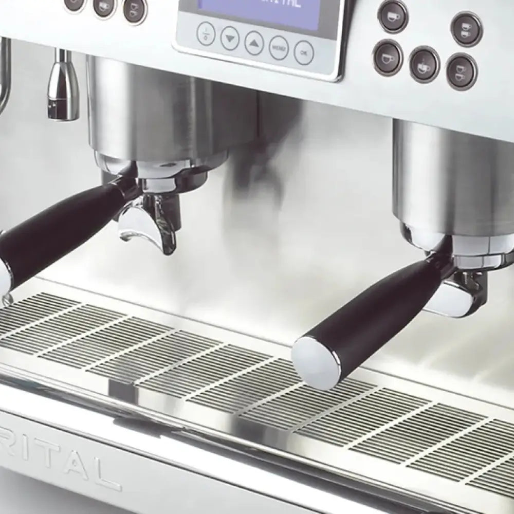 Detail shot of the two group heads and dual portafilters on the Iberital New PID machine, with steaming visible above the drip tray.
