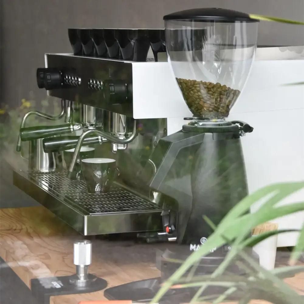 Iberital Referent 2 Group espresso machine alongside a coffee grinder, with cups stacked, on a wooden counter.