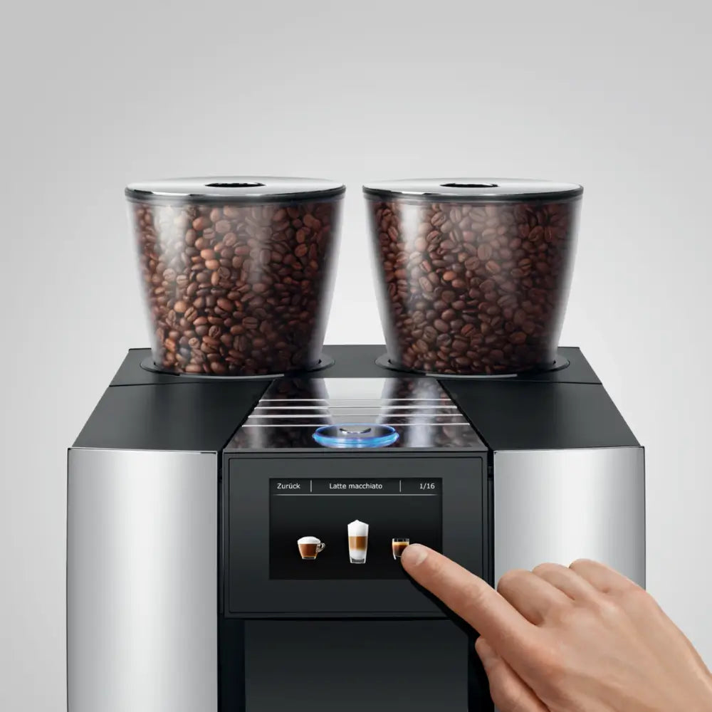 Top view of Jura Giga X8c automatic coffee machine showing dual bean hoppers and drink selection display