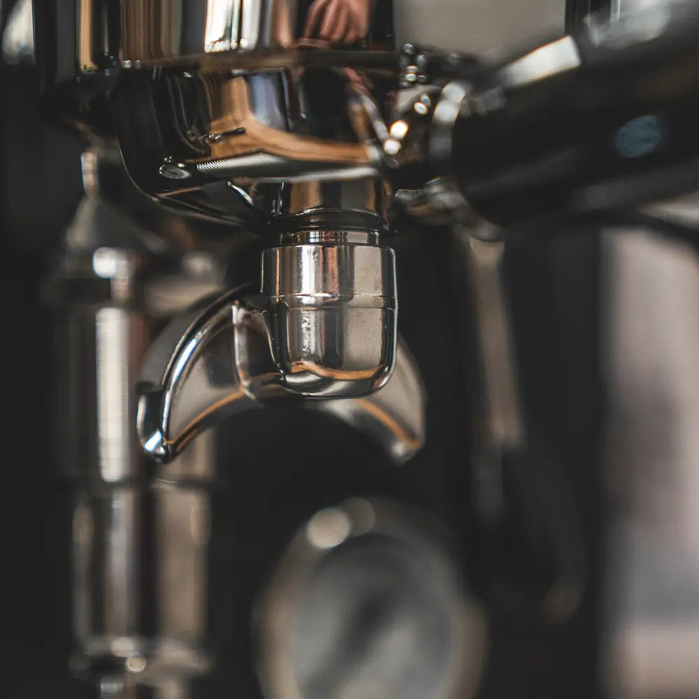 Extreme close-up of the chrome brew group head and portafilter locking area on the Cellini Evolution.