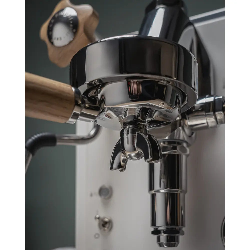 Close-up of the chrome brew group and wooden portafilter handle on the La Pavoni Mini Cellini.
