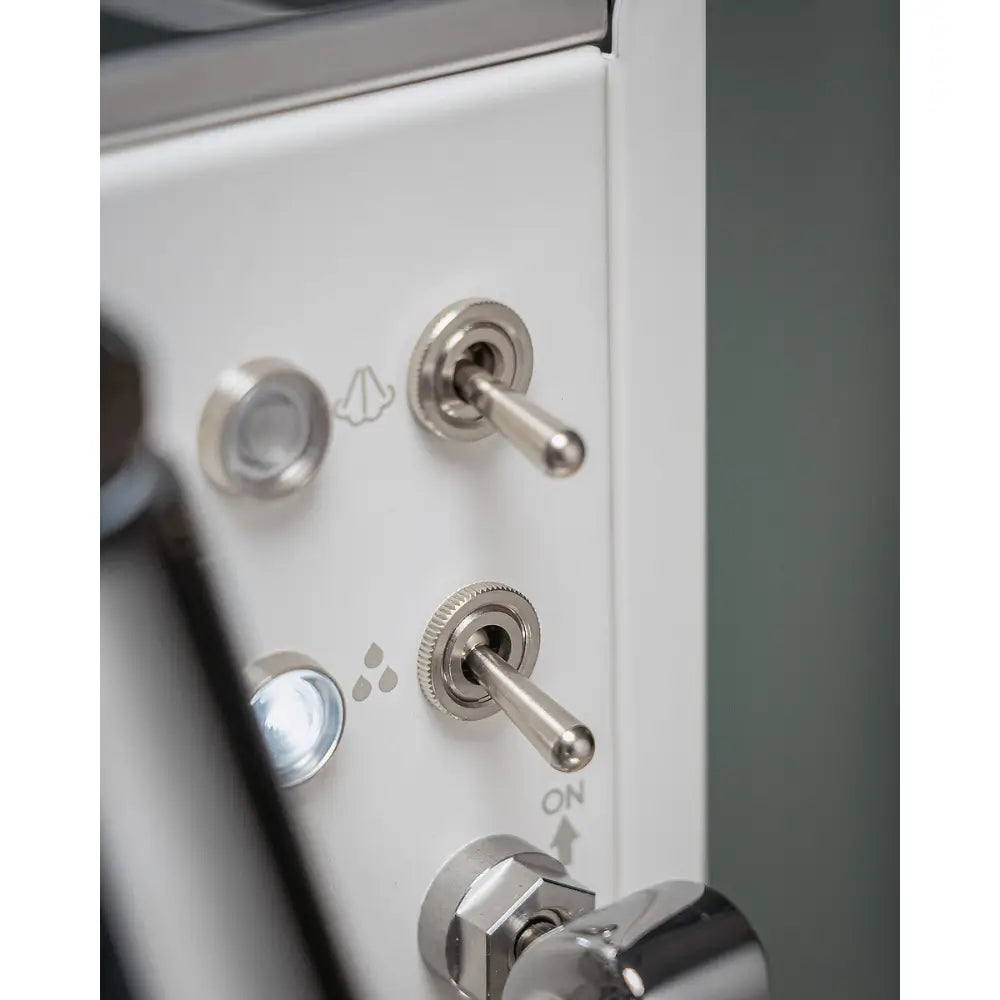 Close-up of the chrome toggle switches on the white body panel of the La Pavoni Mini Cellini.
