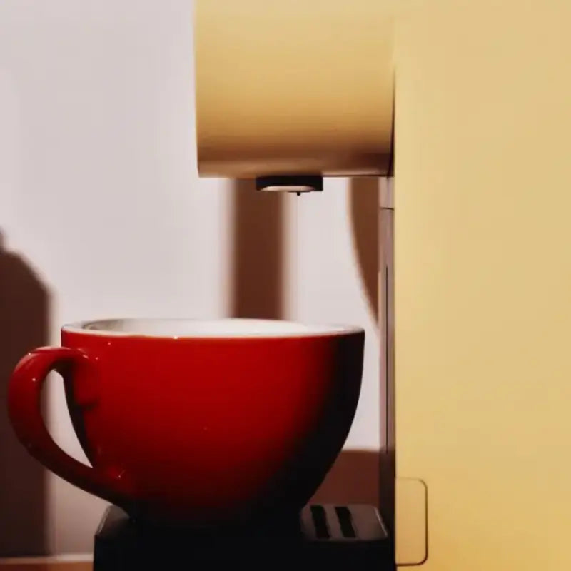 Morning Mini Coffee Machine 220v brewing coffee into a red cup.