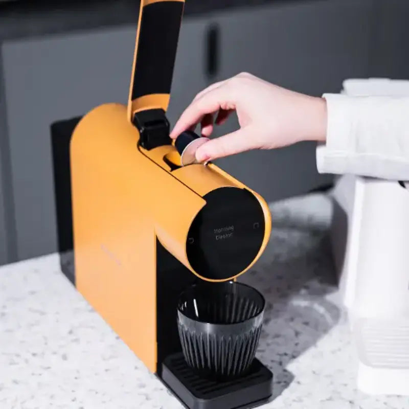 Hand inserting coffee capsule into the Morning Mini Coffee Machine 220v