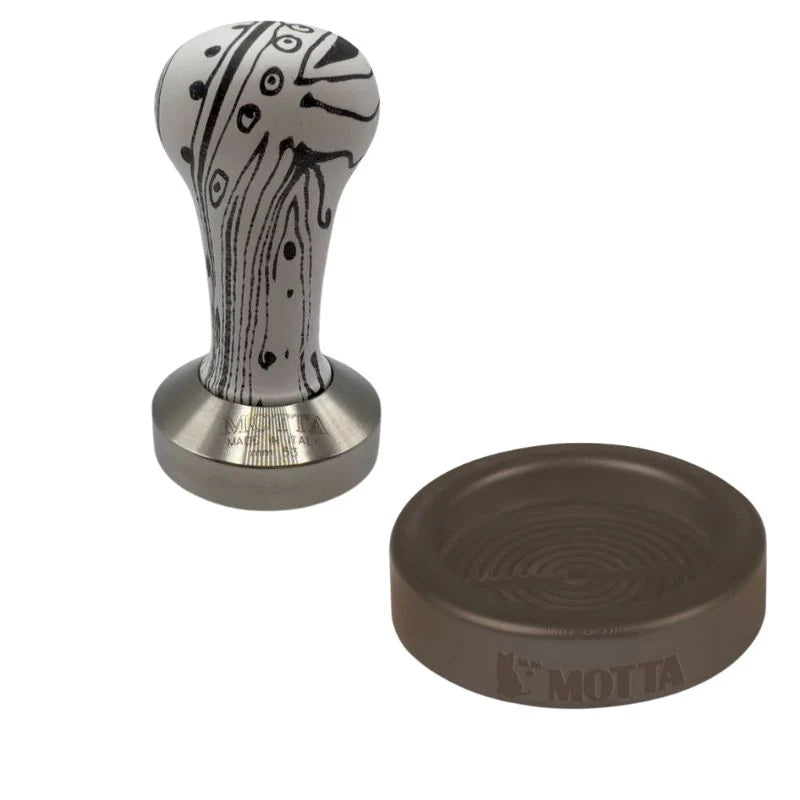 Motta coffee tamper with artistic handle design and matching rubber holder
