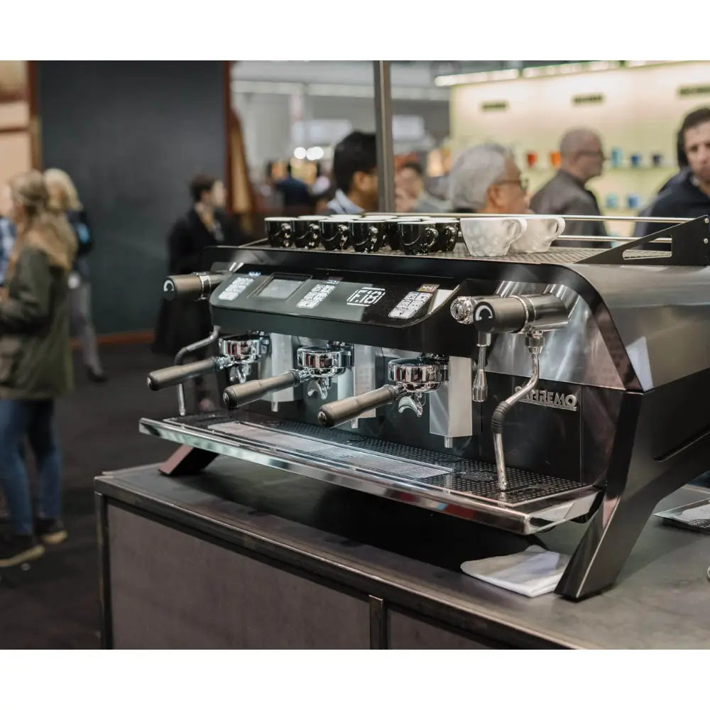 Angled view of the black Sanremo F18 MB installed on a busy commercial bar, ready for high-volume use.