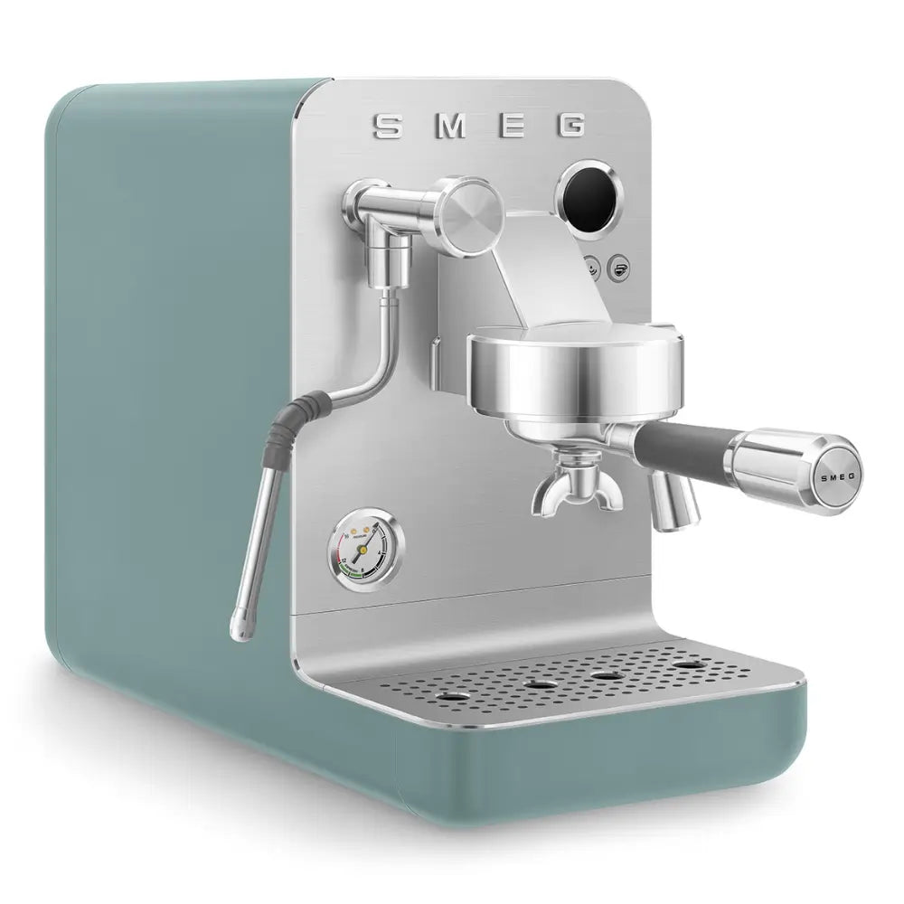 Angled view of the SMEG Collezione Minipro espresso machine in silver and emerald green with a pressure gauge.
