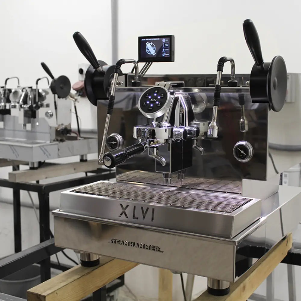 XLVI Steamhammer E espresso machine in a commercial setting, highlighting the volumetric controls and digital display.